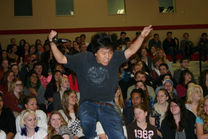 At Tuesday's, Crossover Assembly, junior TJ Cha leaps down from the bleachers to recieve a perfect attendance award for two years. 